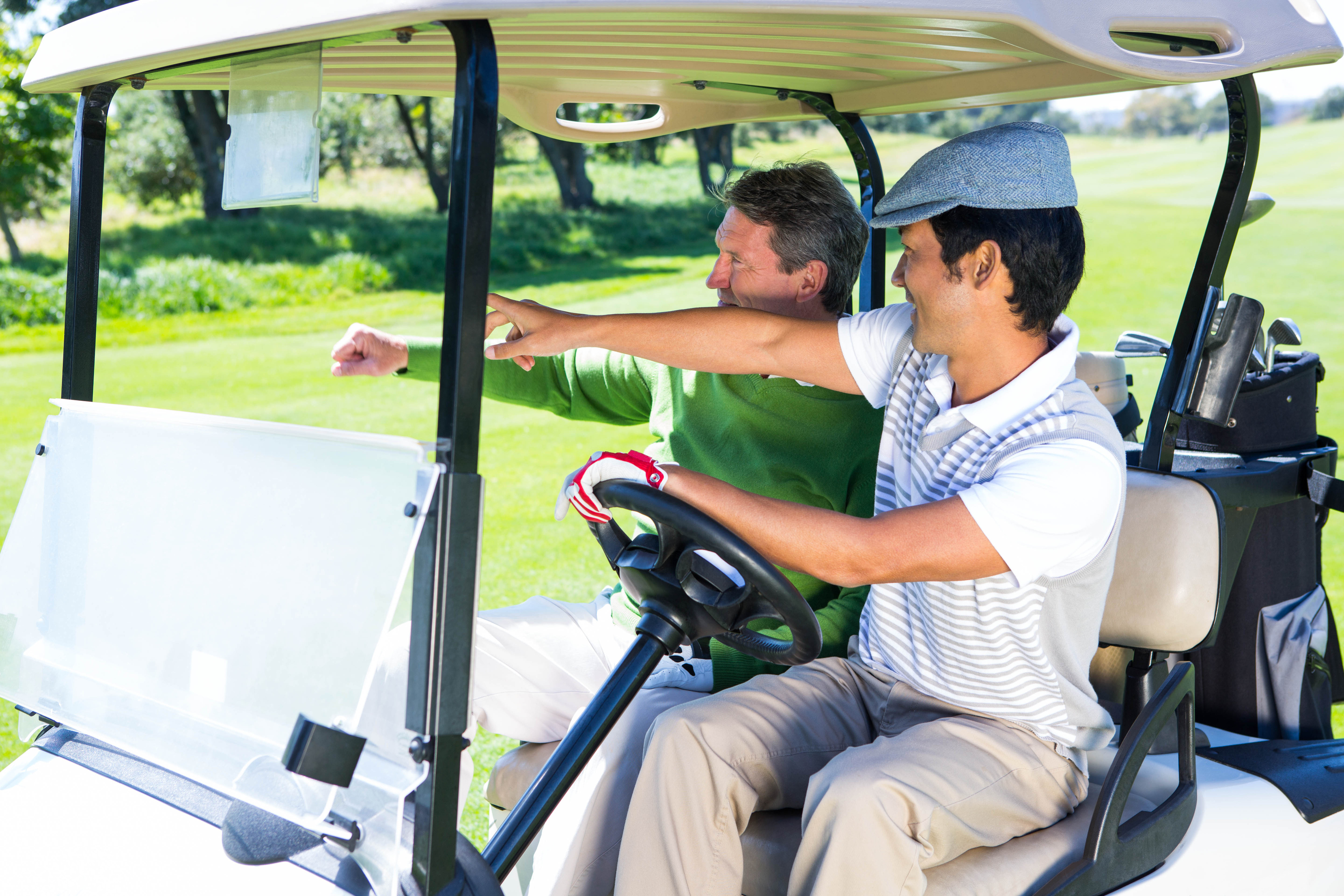 Golfing friends driving in their golf buggy